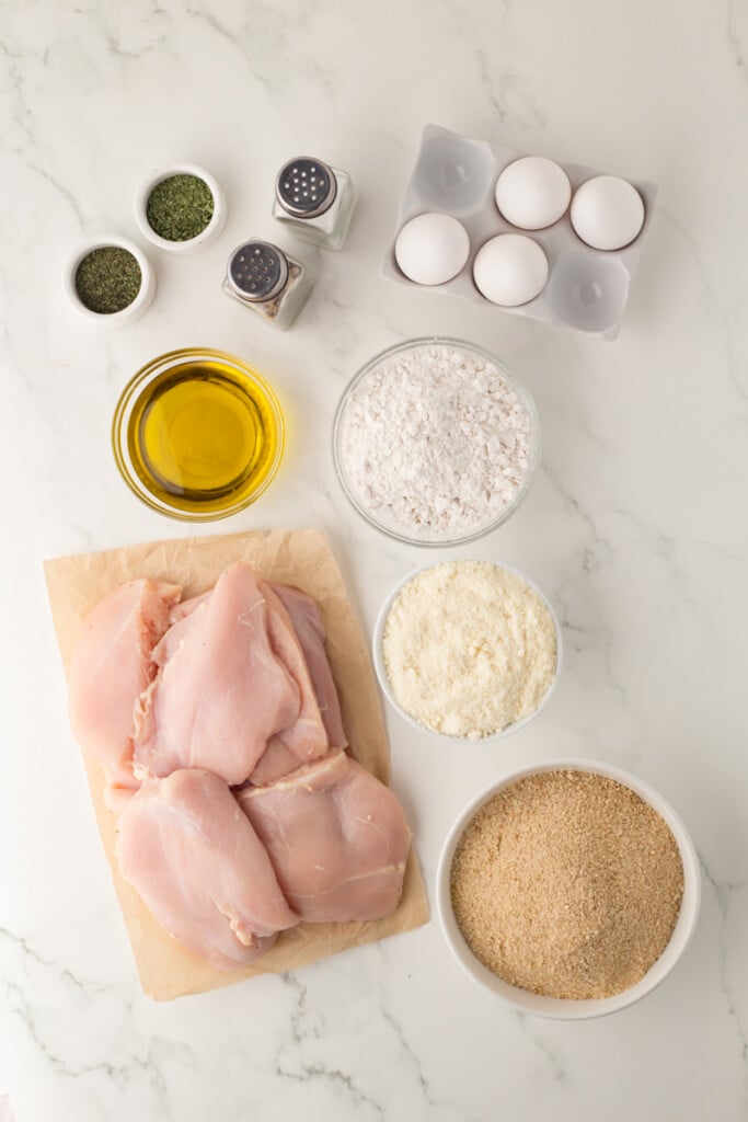 Italian Chicken Cutlets with herbs, breading, and seasonings ready for cooking.