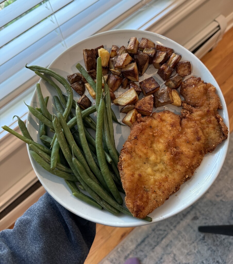Italian Chicken Cutlets on a plate with potatoes and green beans